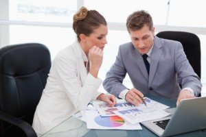 Business plan guide: researching your market & getting funding - image - Suited man and woman in a meeting discussing graphs