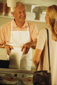 A Recipe for Success with your Start Up Food Business - image - man wearing apron serves woman in shop