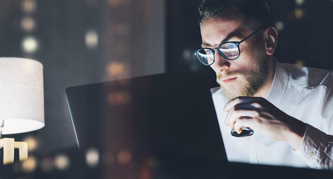 Obstacles You'll Face Starting a Business image - bespectacled man working on a laptop at night