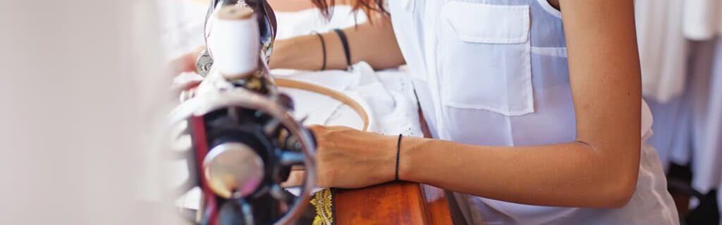 Young woman using a sewing machine for her fashion brand