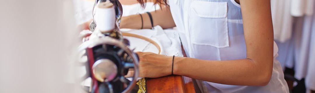 Young woman using a sewing machine for her fashion brand