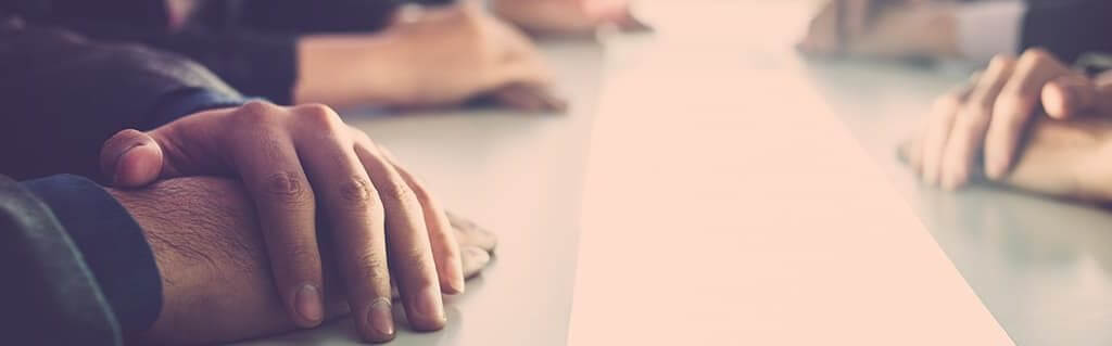 Apprentice Start-up Errors image - close of of people hands resting on a board room table