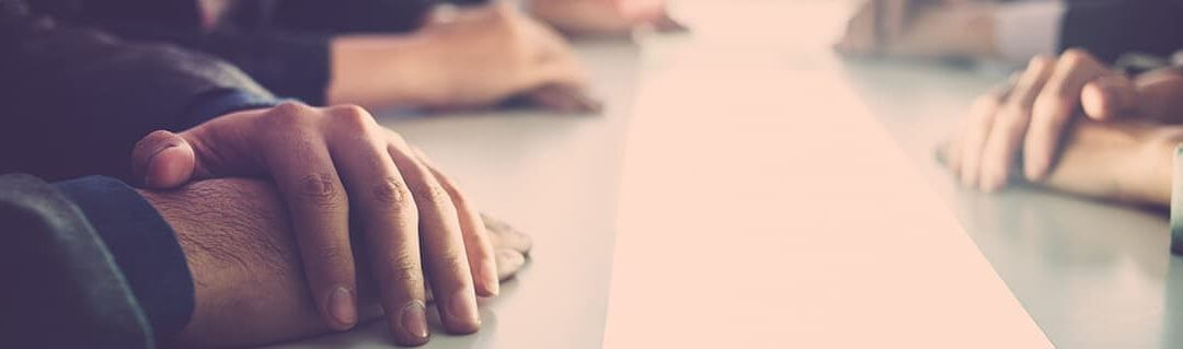 Apprentice Start-up Errors image - close of of people hands resting on a board room table