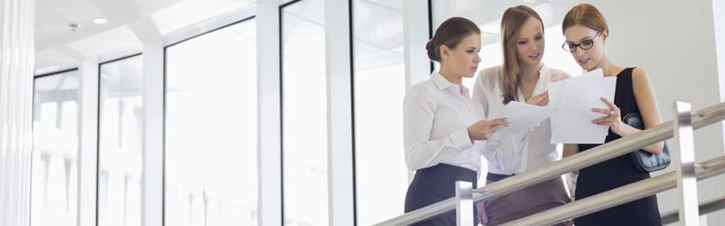 Female entrepreneurs looking at documents in an office for international womens day