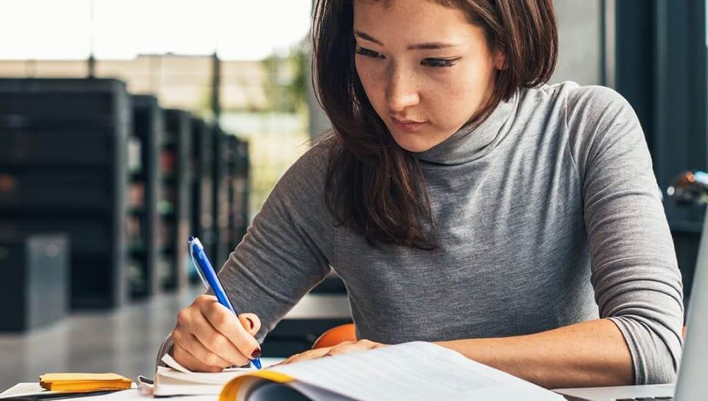 Entrepreneur Award 2017: Winner Announcement image - woman in grey writing in a notebook