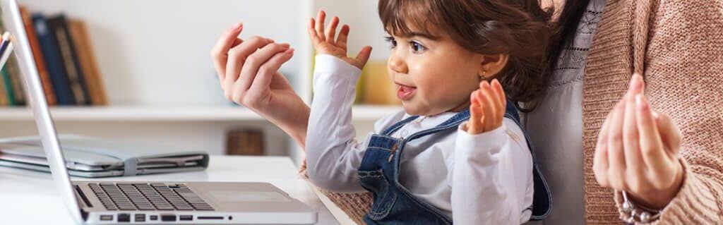 A mother working from home at the computer with her daughter