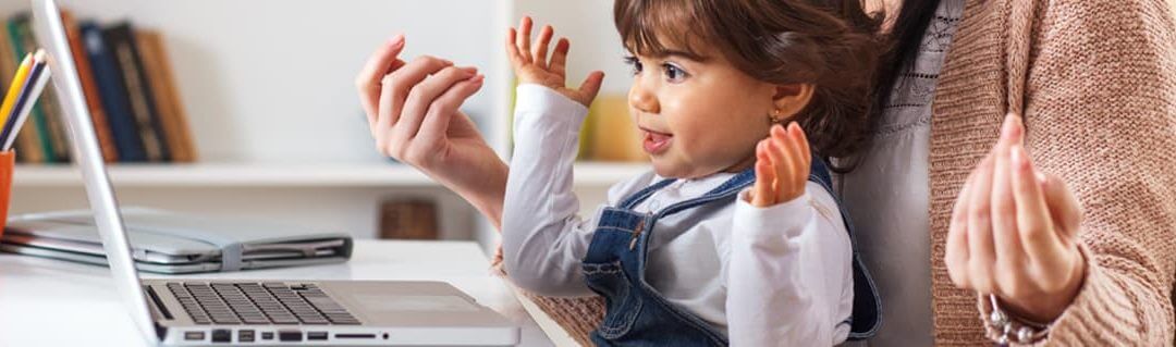 A mother working from home at the computer with her daughter