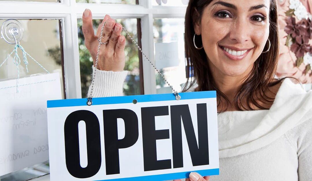 Female shop owner holding an open sign