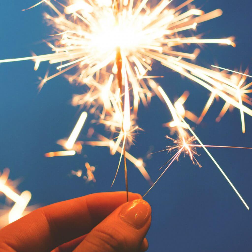 The Road So Far: Our 2017 Journey image - hand holding sparkler against blue background