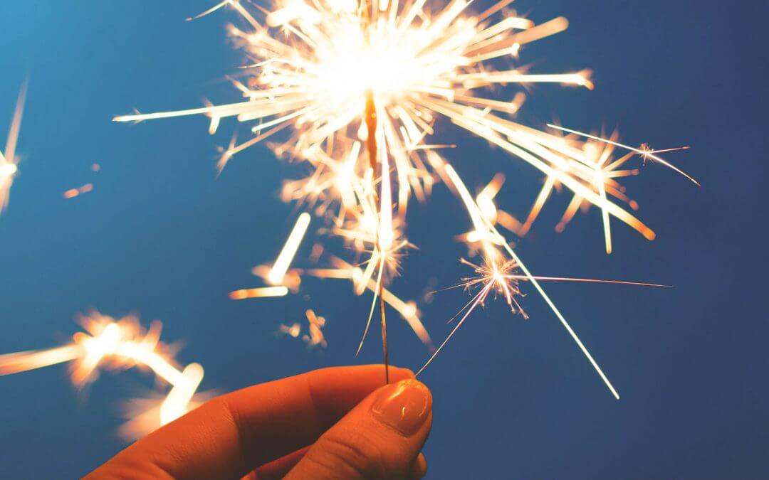 The Road So Far: Our 2017 Journey image - hand holding sparkler against blue background