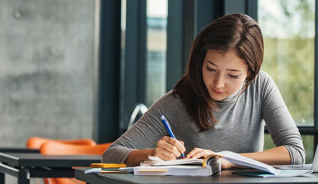 Top 10 resources for business startups image - woman at desk writing in book