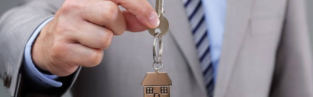 Top Tips On Property Development image - man in a suit offering a bunch of keys