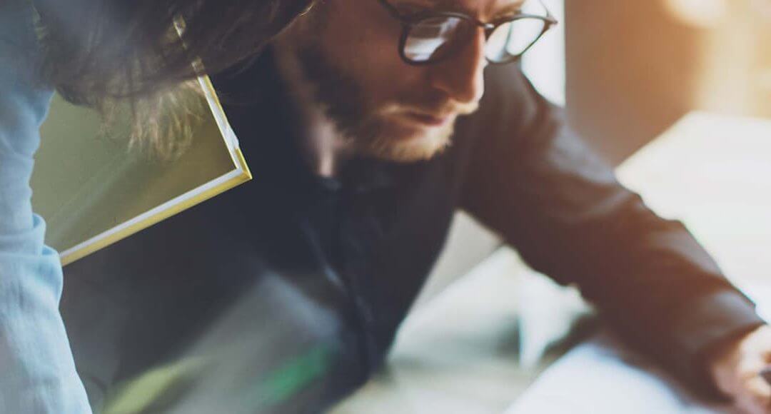 What Does It Mean to be a Project Manager in the Startup World? - image - man at desk with glasses on