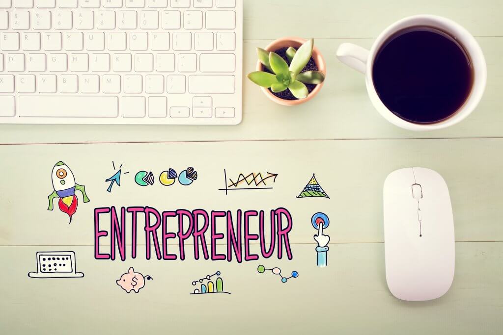 Image - Entrepreneur concept illustration with workstation on a wooden desk, with a keyboard, plant and coffee